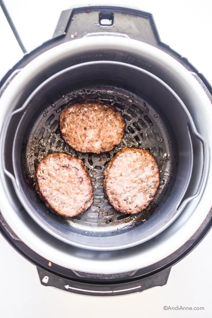 cooked burger patties in an air fryer