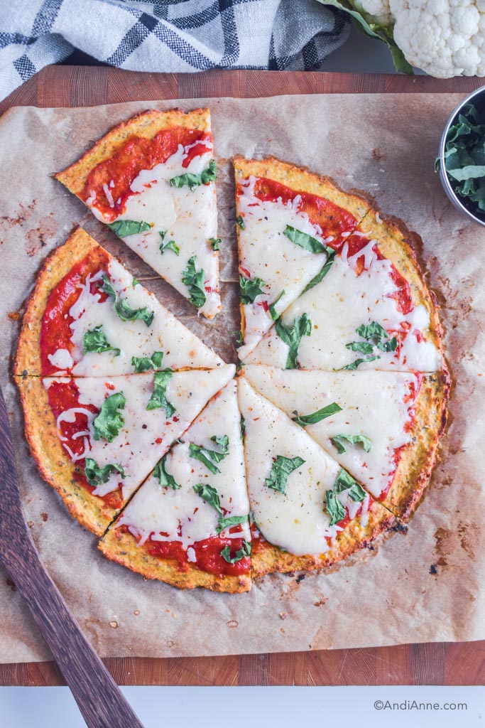 sliced margherita pizza with cauliflower crust on parchment paper