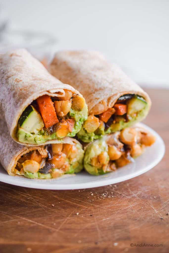 chickpea zucchini stir fry wraps piled on top of eachother on a white plate