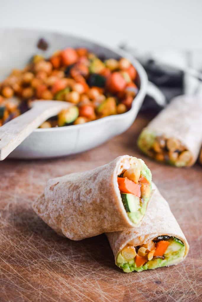 chickpea zucchini wraps stacked on top of eachother with stir fry in frying pan in background.