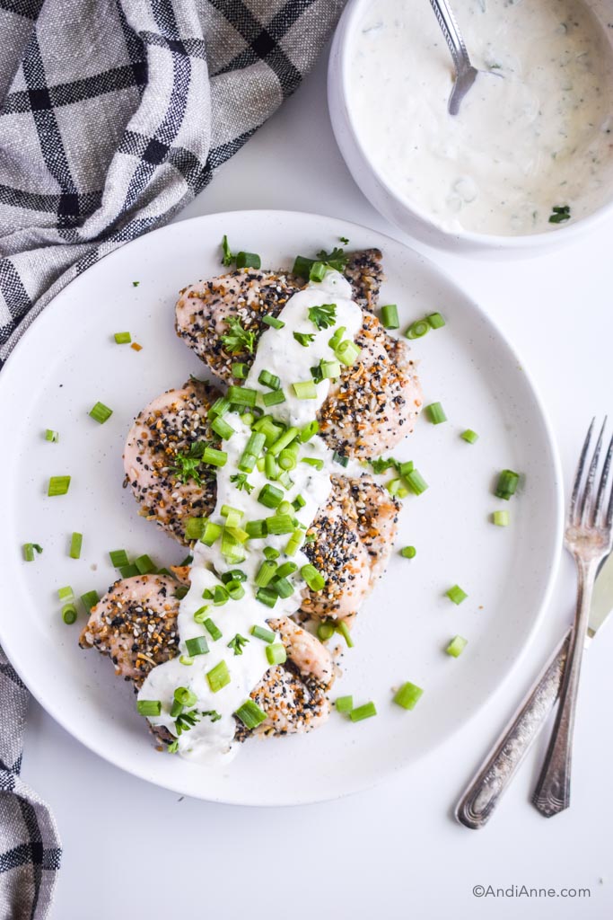 everything bagel chicken breasts with greek yogurt dressing on a white plate