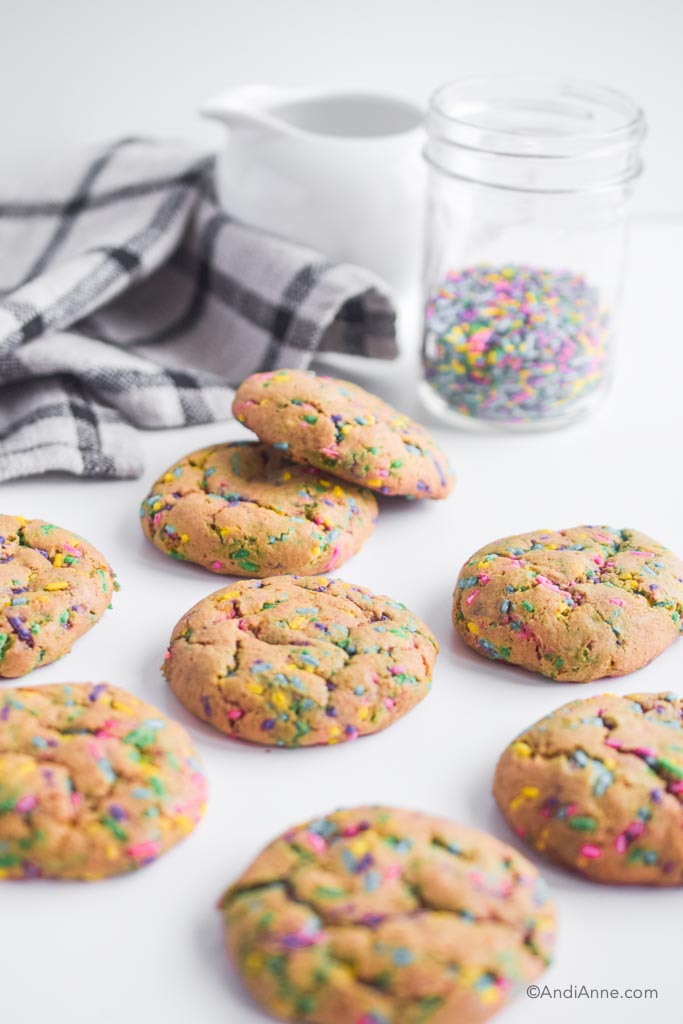 gluten-free sprinkle cookies on a counter with kitchen towel and sprinkles in background