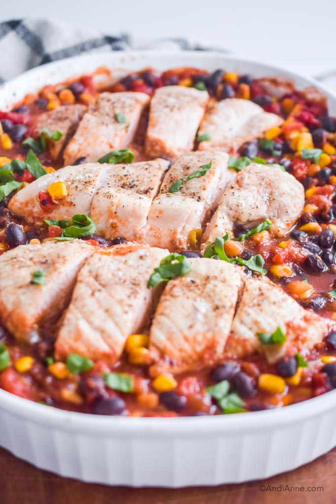 close up of dump and bake salsa chicken in a white baking dish. 