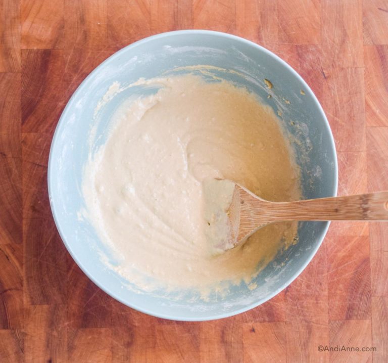 wet pancake batter in a blue bowl with wooden spoon
