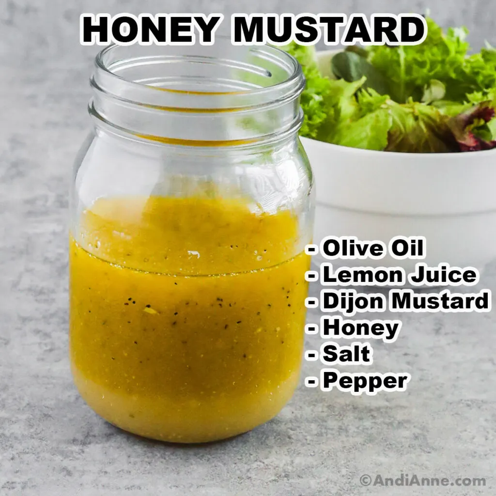 A mason jar of honey mustard dressing with the ingredients listed beside it including olive oil, lemon juice, dijon mustard, honey, salt and pepper