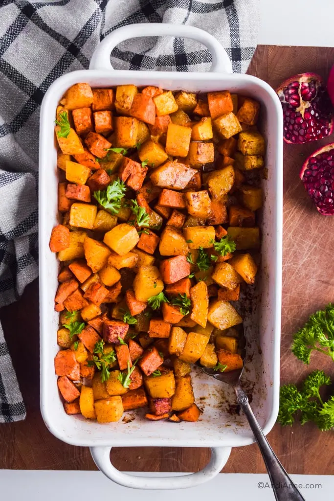 roasted squash and sweet potato with cinnamon in a white casserole dish.