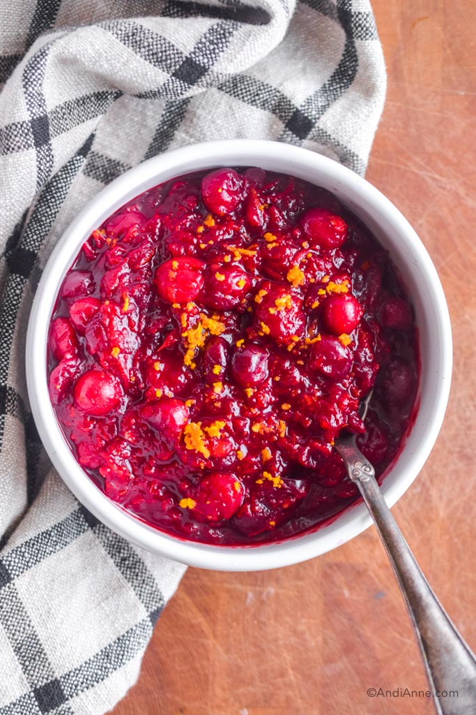 cranberry sauce in a white bowl with silver spoon. 
