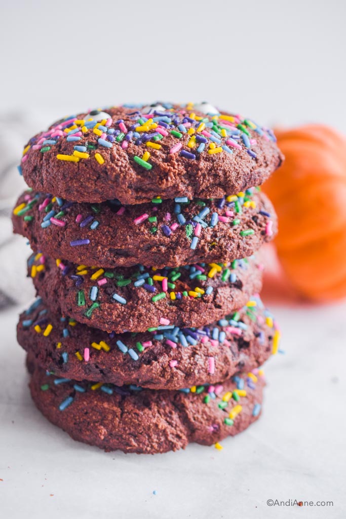 chocolate cookies with sprinkles stacked on top of eachother