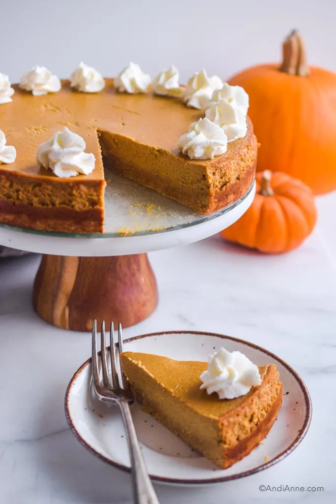 low sugar pumpkin cheesecake on a serving dish with fork and pumpkins in background