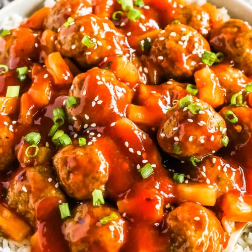 A plate of sweet and sour meatballs over rice.