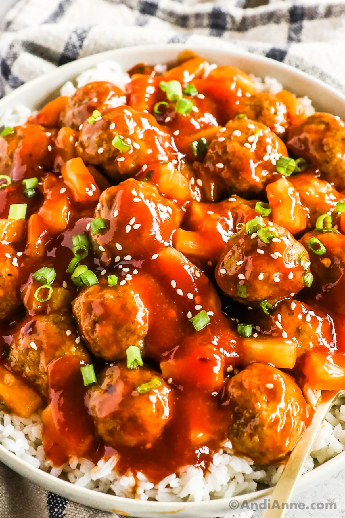 A plate of sweet and sour meatballs over rice.