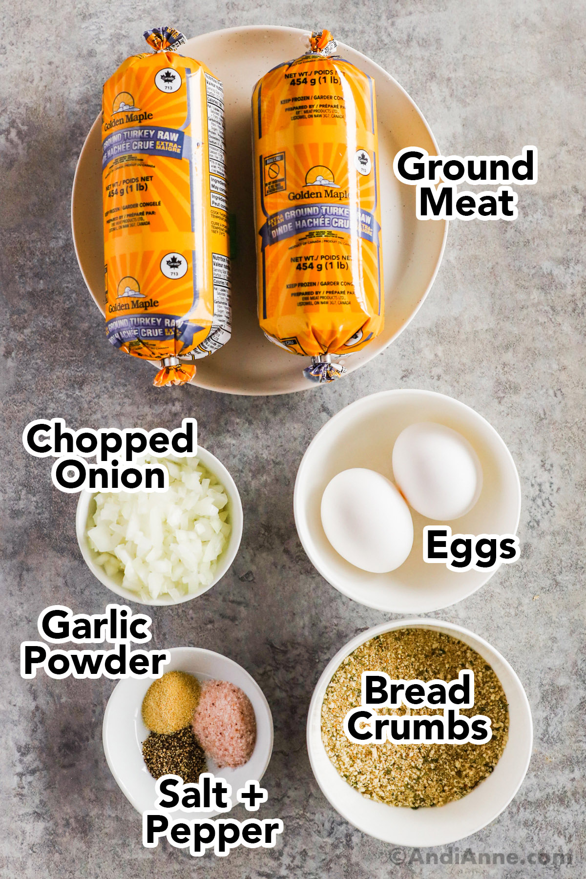Recipe ingredients including tubes of ground turkey, bowls of chopped onion, bread crumbs, eggs and spices.