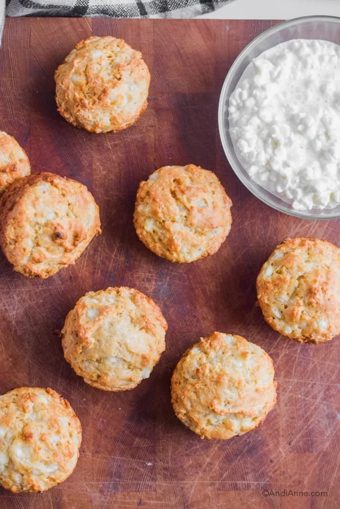 looking down at cottage cheese muffins with a bowl of cottage cheese on a butcher block