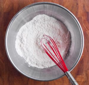 steel bowl with flour and whisk