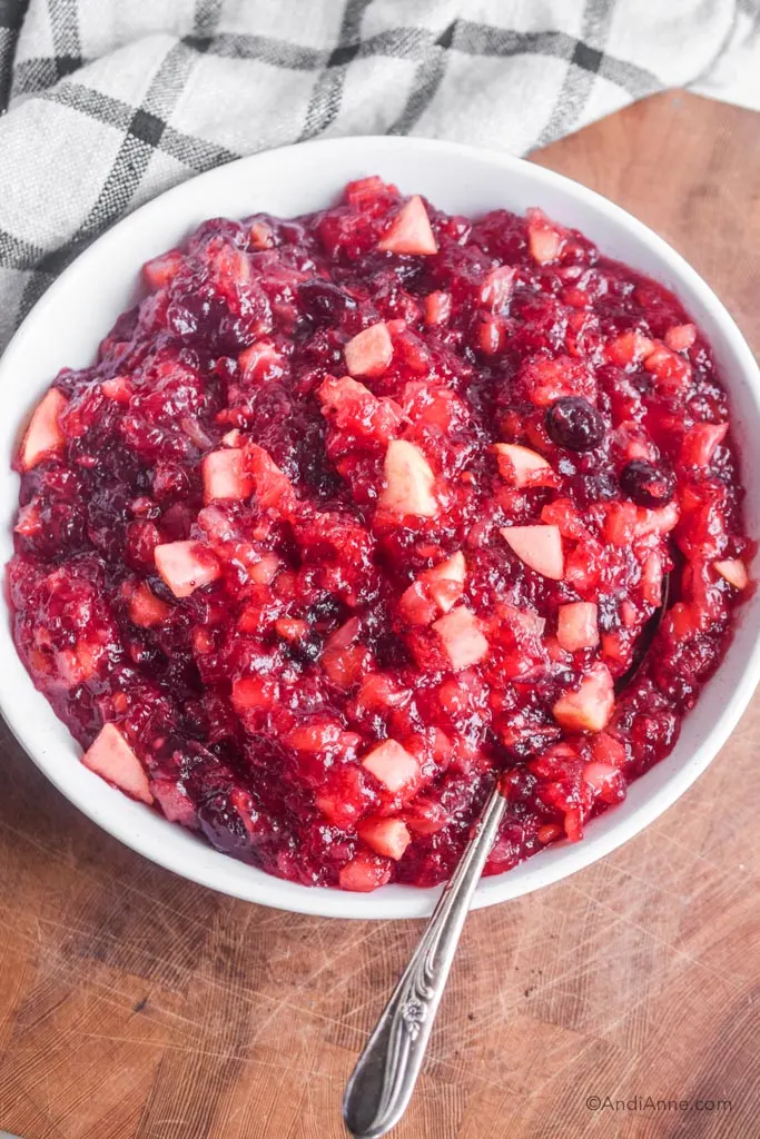 cranberry pineapple jello in a white bowl with spoon
