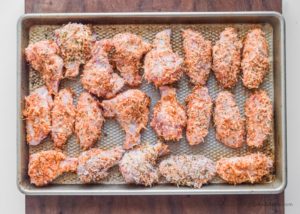 baking sheet with parmesan covered raw chicken wings in a single layer