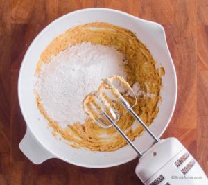 wet batter with white flour on top and hand mixer