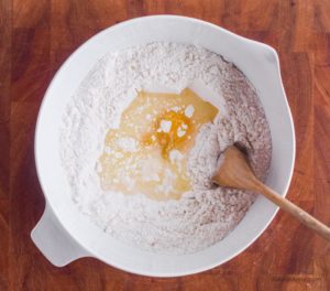 bowl with flour and egg with wood spoon