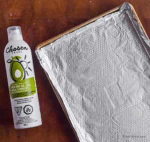 baking sheet lined with aluminum. Avocado oil spray beside baking sheet.
