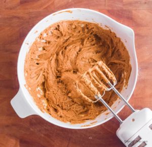 wet batter in white bowl with hand mixer