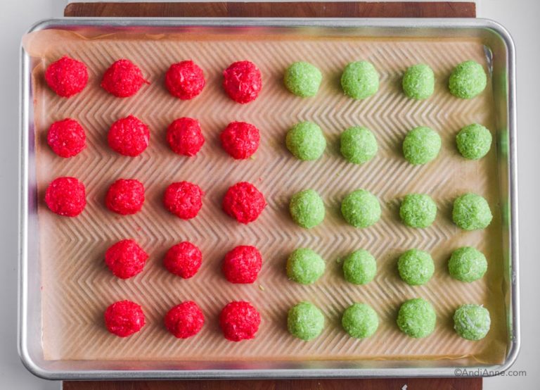 rolled green and red jello balls on a baking sheet.
