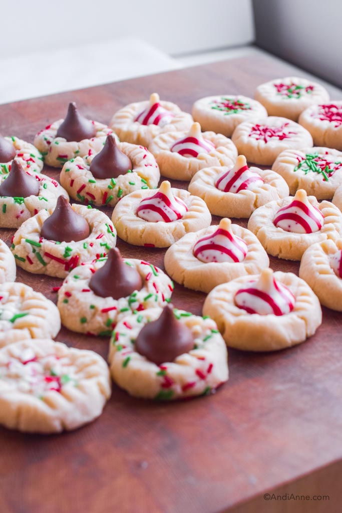 Side angle of shortbread cookies with hershey's kisses in center. Some chocolate, some striped peppermint.