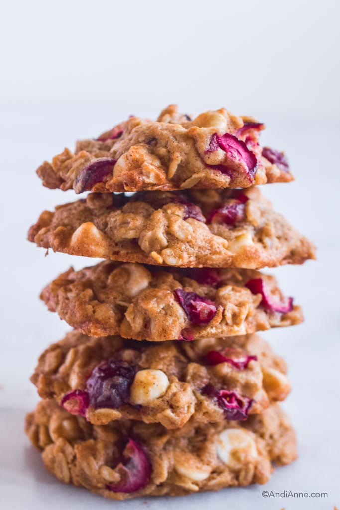 A stack of white chocolate oatmeal cranberry cookies piled on top of eachother. 
