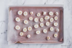 sliced banana on baking sheet with parchment paper