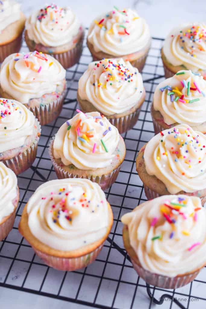 white confetti sprinkle cupcakes all on a baking rack