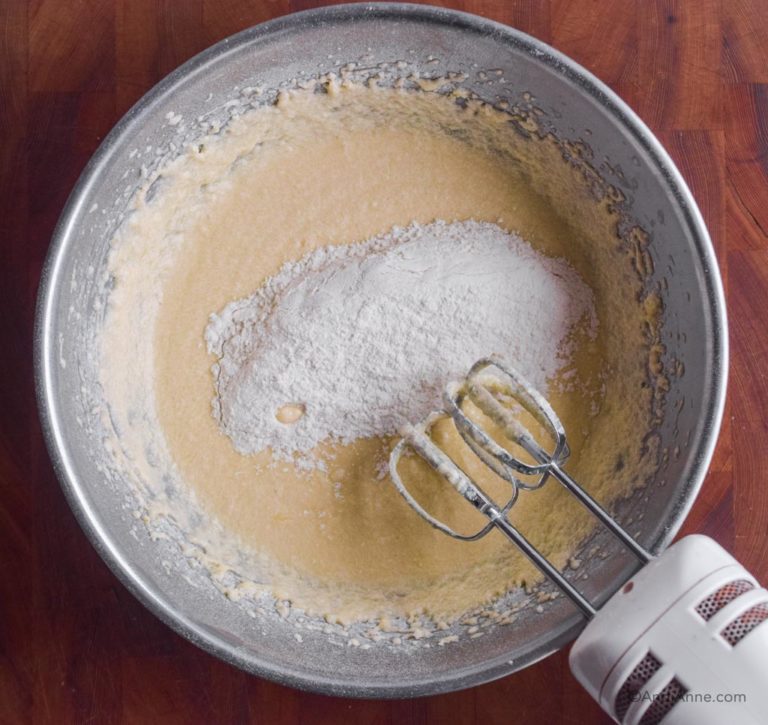 wet batter with dry flour ingredients dumped on top and hand mixer