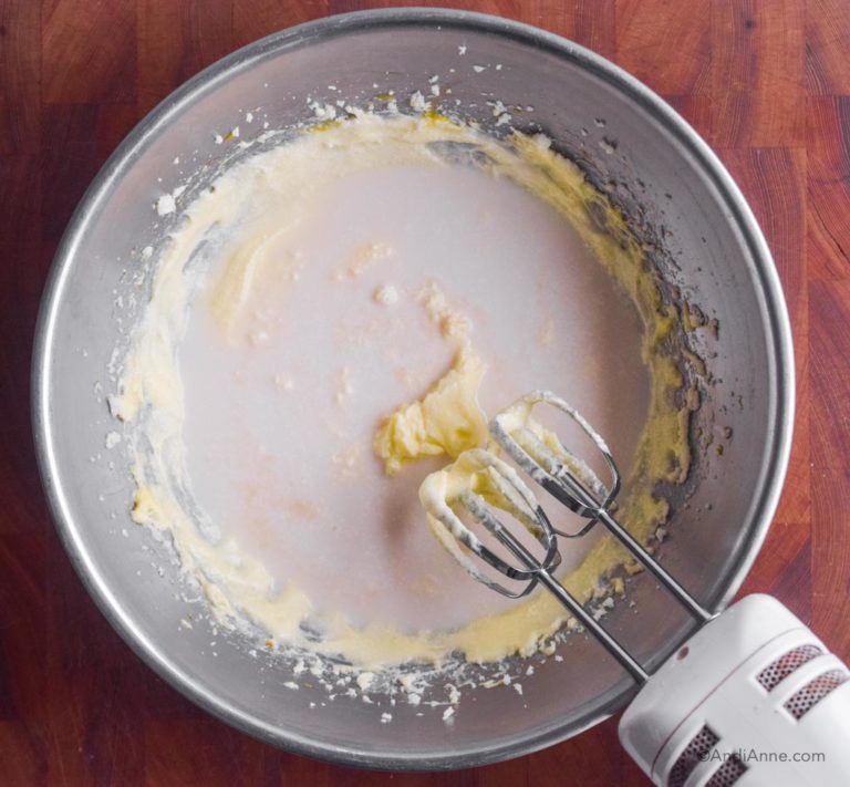 wet batter with milk poured on top and hand mixer beside