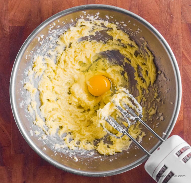 steel bowl with creamed butter and raw egg and hand mixer