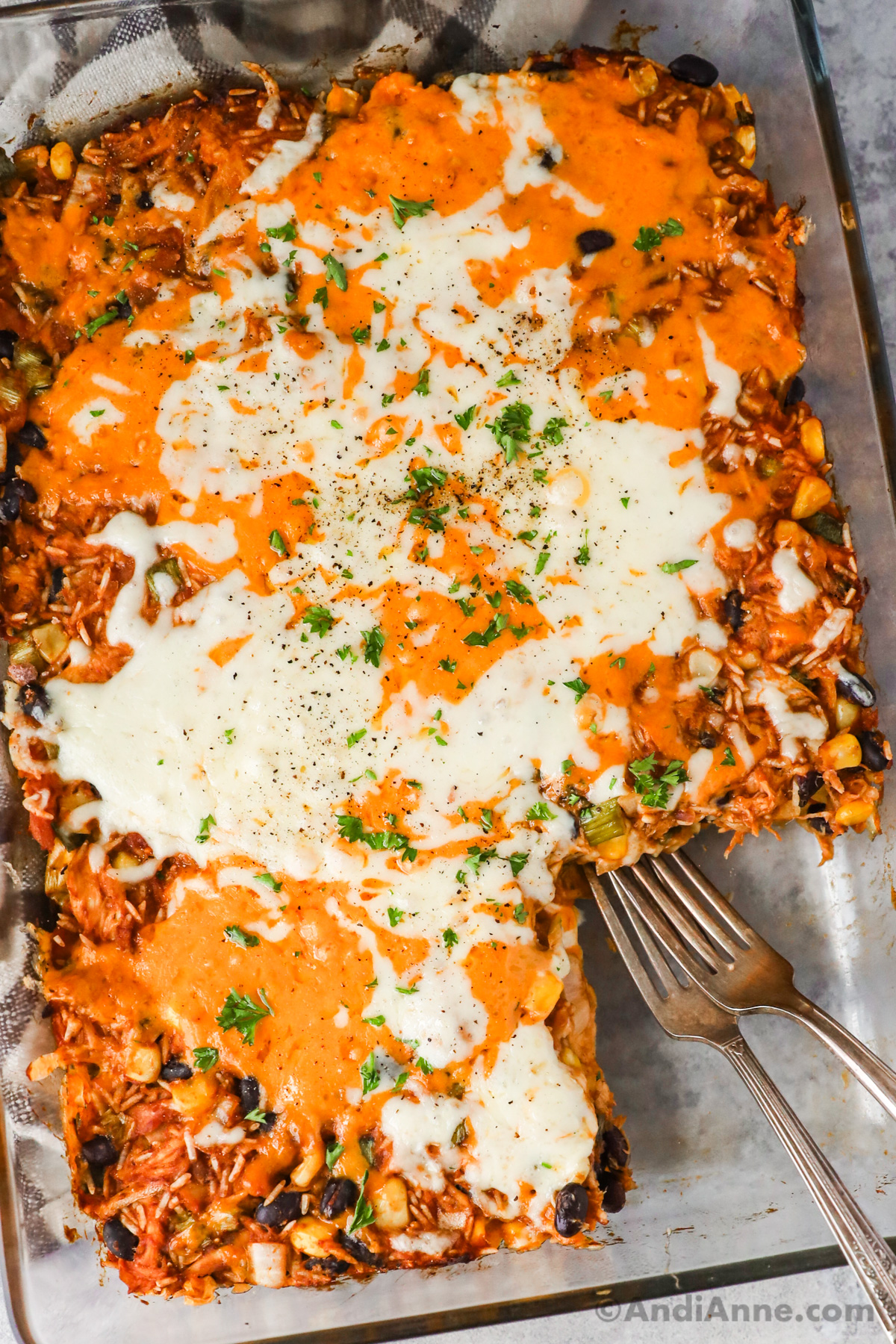 Barbecue shredded chicken casserole topped with melted cheese and two forks