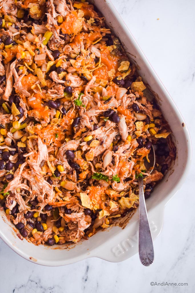 Close up of shredded barbecue chicken casserole with a spoon in it.