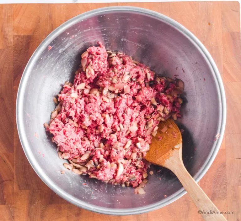 ground beef mixture in a large steel bowl with wood spatula