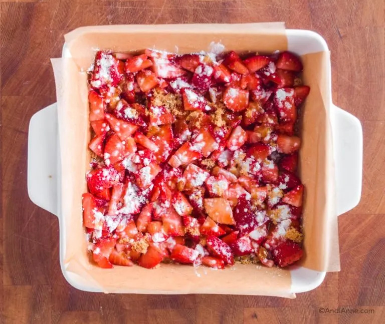 cornstarch and brown sugar sprinkled on top of chopped strawberries in square dish