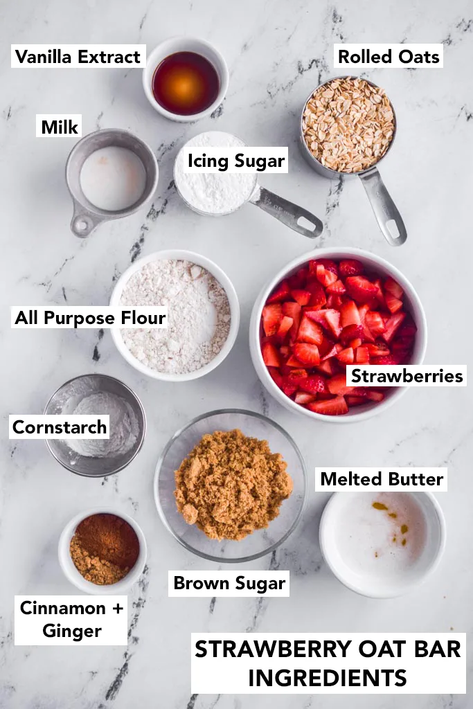 Ingredients for recipe in bowls: vanilla extract, milk, icing sugar, rolled oats, flour, strawberries, cornstarch, brown sugar, melted butter, cinnamon and ginger.