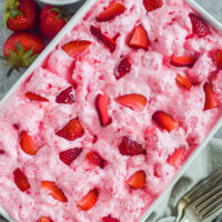 A white dish with strawberry angel food cake dessert.