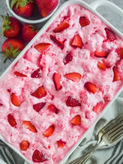A white dish with strawberry angel food cake dessert.