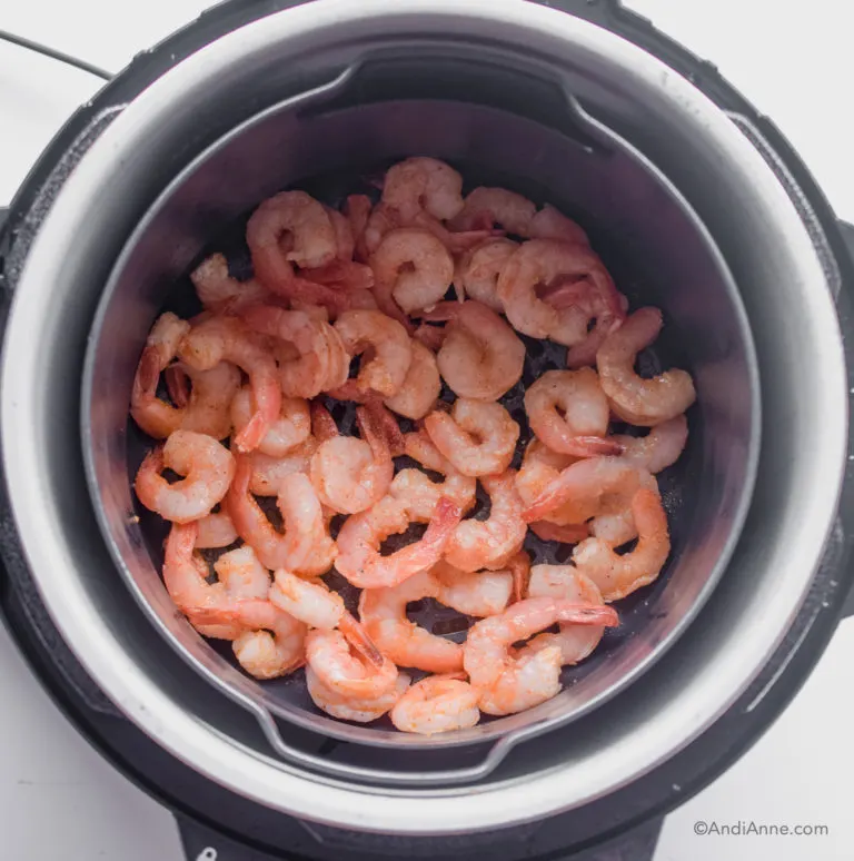 Looking down at air fryer with shrimp inside.