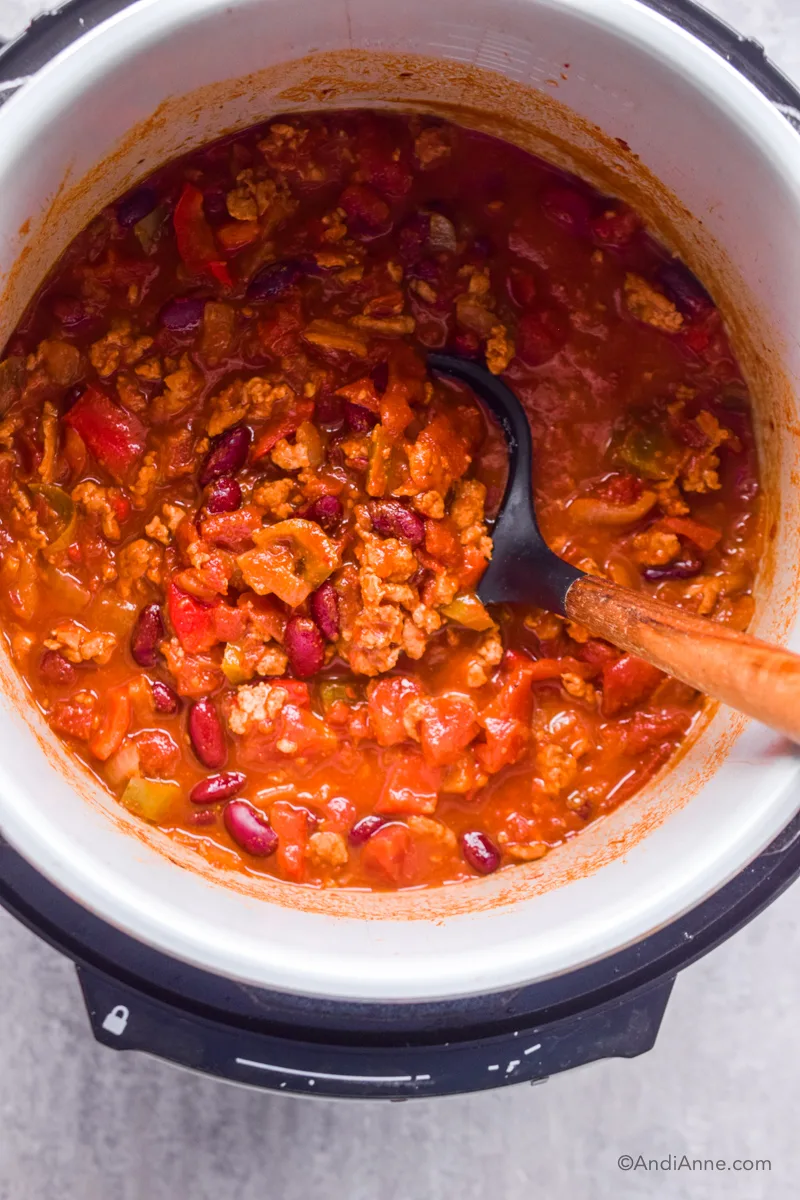 Looking down at instant pot with recipe and soup spoon.