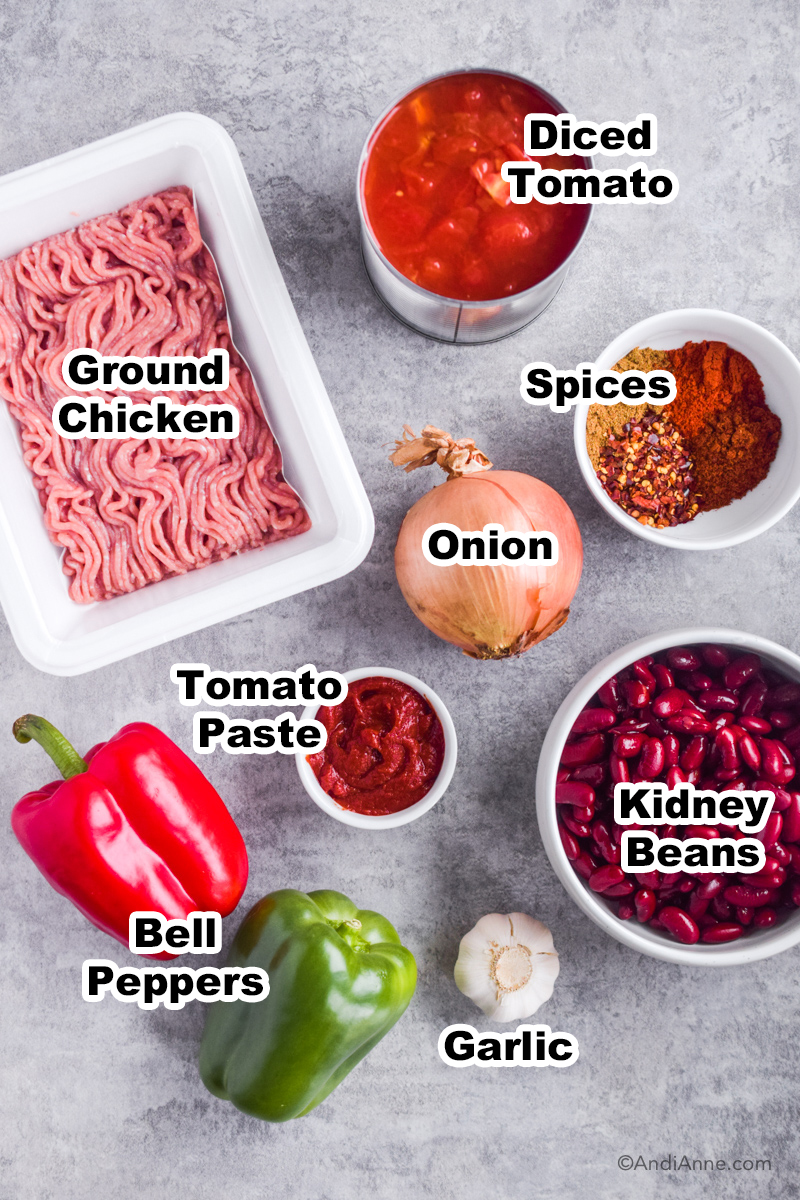 Ingredients to make recipe on counter including ground chicken, kidney beans, bell pepper and a bowl of spices.