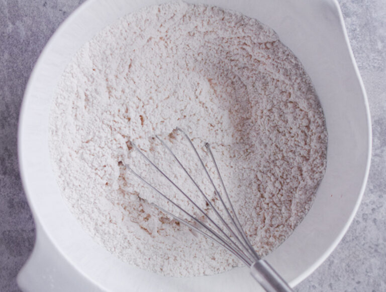 Dry ingredients in bowl with a whisk.