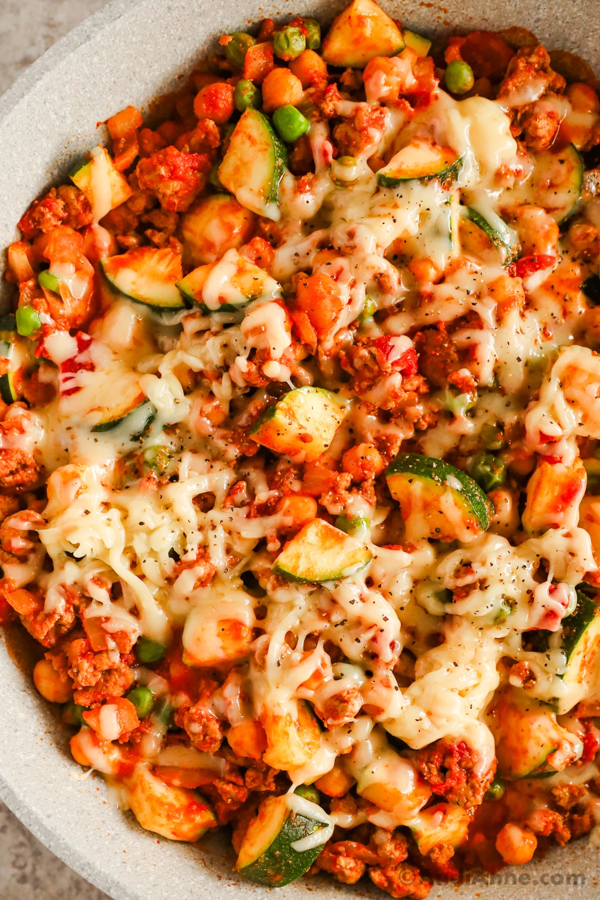 Close up of ground turkey zucchini skillet recipe topped with melted cheese