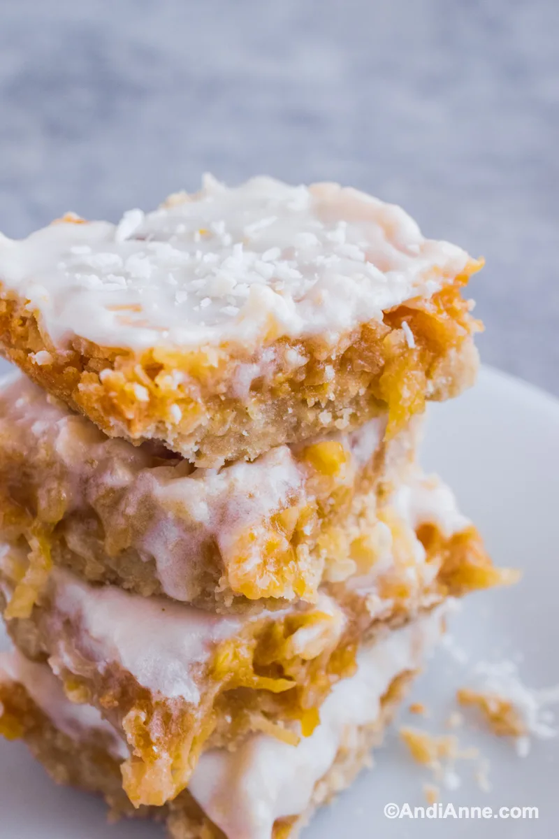 Close up of four lemon squares stacked on top of eachother.