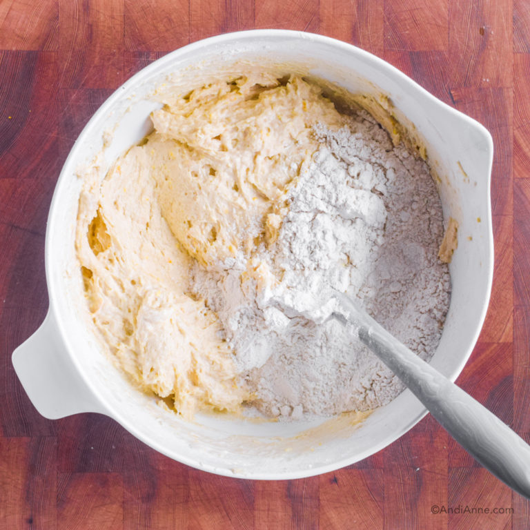 Batter with flour mixture in white bowl and spatula.