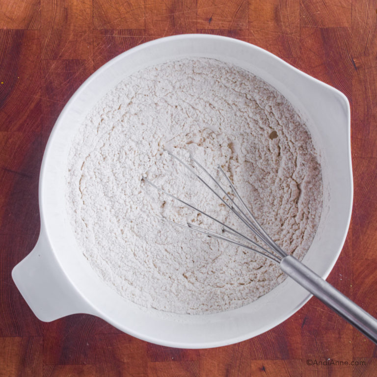 Flour mixture in white bowl with whisk.