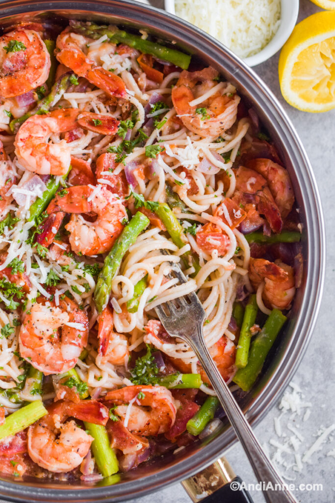a pot of shrimp asparagus pasta with a fork inside
