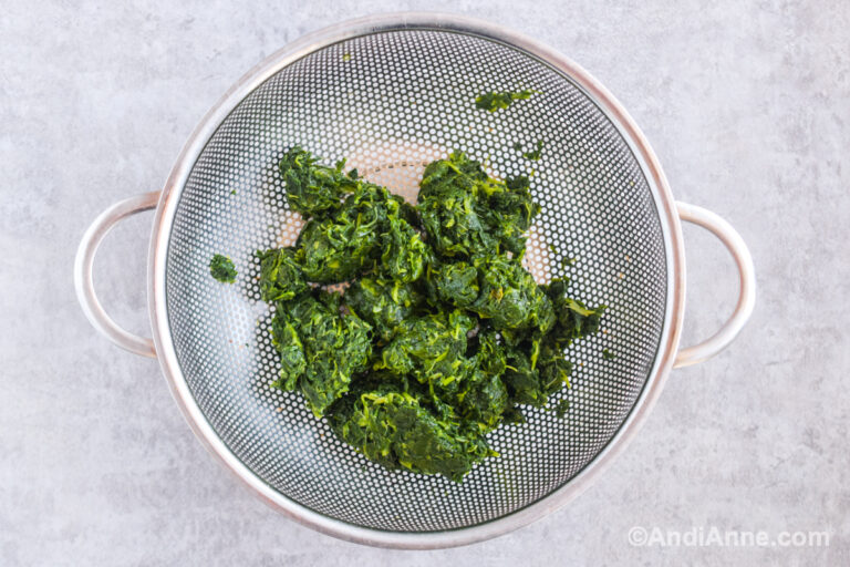 Squeezed, thawed spinach in a strainer.