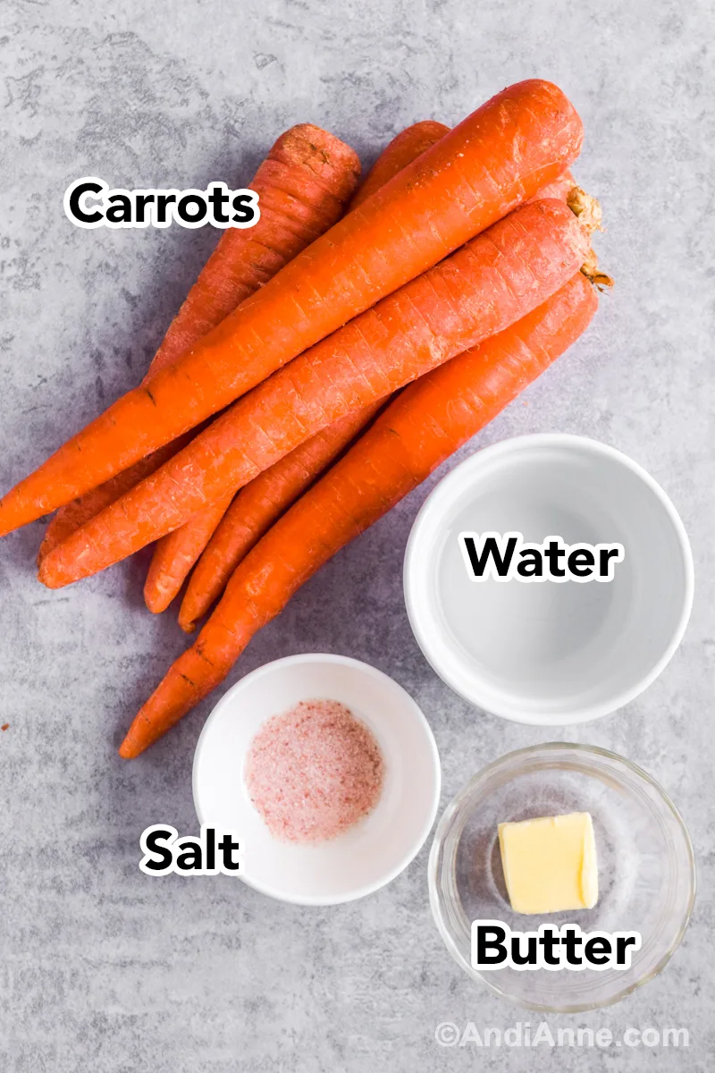 Recipe ingredients on the counter including carrots, bowl of water, salt and butter.